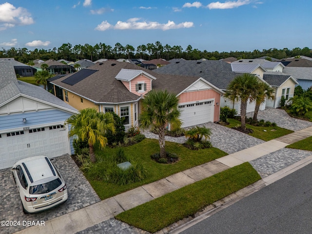 ranch-style home featuring a garage and a front lawn