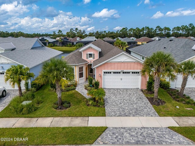 1078 Castaway Ct, Daytona Beach, FL 32124 - view of front of property with board and batten siding, a garage, a residential view, and a front yard