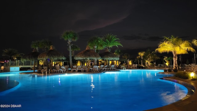 pool at night with a patio area