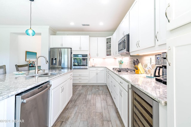 kitchen featuring white cabinetry, wine cooler, appliances with stainless steel finishes, light hardwood / wood-style flooring, and pendant lighting