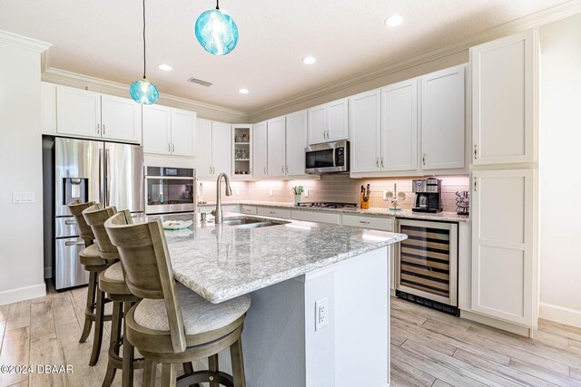 1078 Castaway Ct, Daytona Beach, FL 32124 - kitchen with stainless steel appliances, a sink, beverage cooler, a breakfast bar, and light wood-style flooring