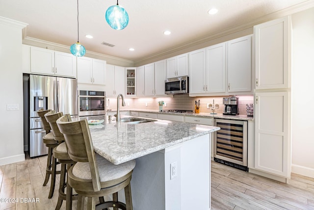 1078 Castaway Ct, Daytona Beach, FL 32124 - kitchen with appliances with stainless steel finishes, a sink, beverage cooler, a kitchen bar, and light wood-style floors