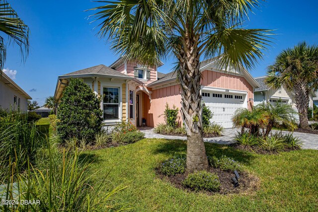 1078 Castaway Ct, Daytona Beach, FL 32124 - view of front of home featuring a garage, concrete driveway, board and batten siding, and a front lawn