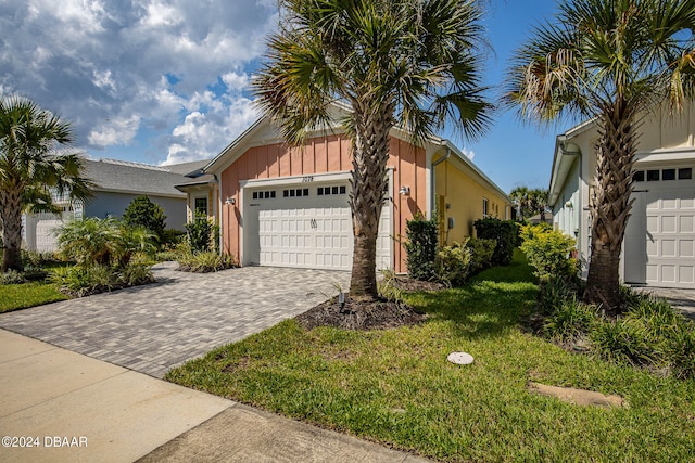 view of front of home with a garage and a front lawn