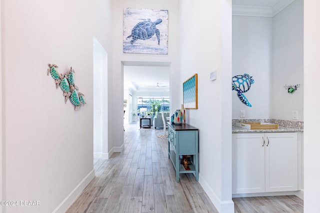 hallway featuring light hardwood / wood-style floors and crown molding