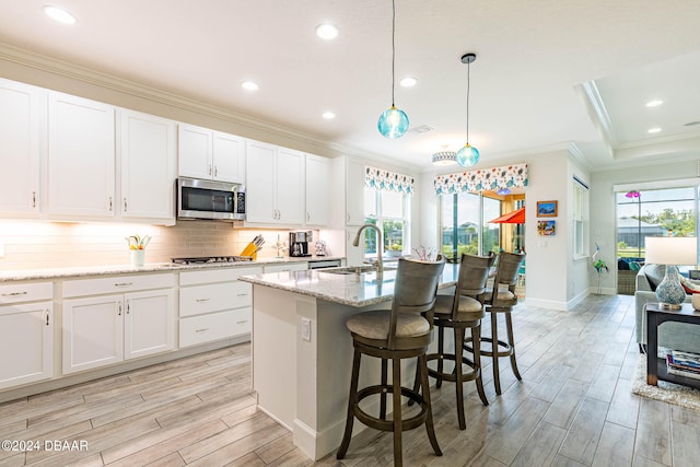 kitchen featuring a wealth of natural light, white cabinetry, appliances with stainless steel finishes, and sink