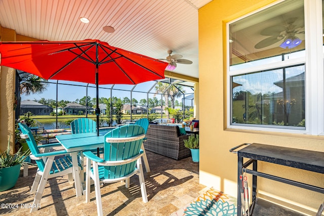 view of patio with ceiling fan and glass enclosure