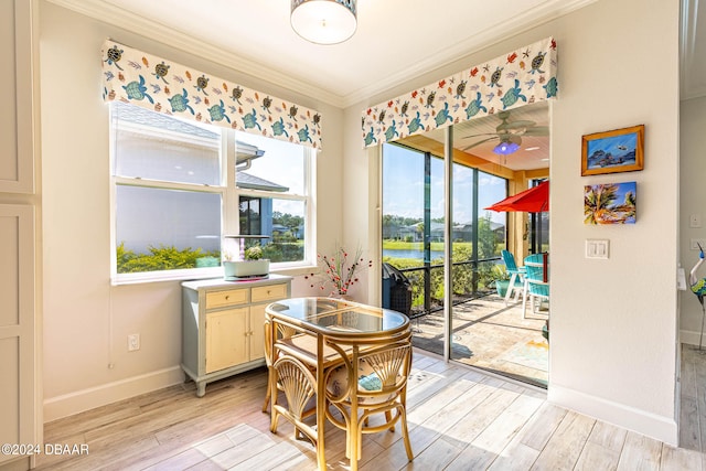 dining room with light wood-type flooring, ceiling fan, and crown molding