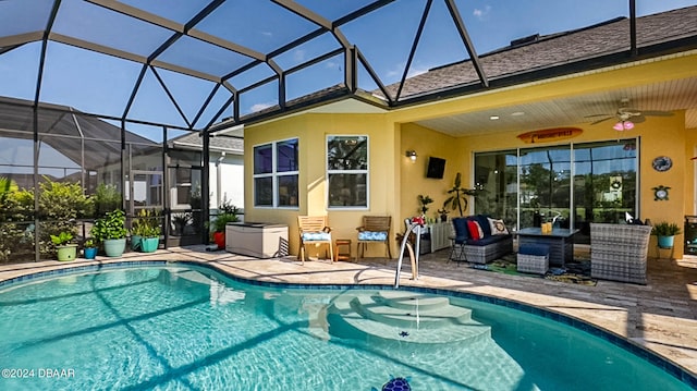 view of pool featuring glass enclosure, a patio area, and ceiling fan