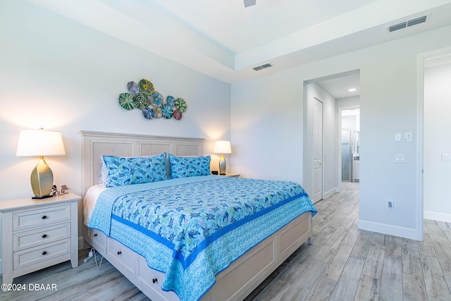 bedroom with light hardwood / wood-style floors, ceiling fan, and a closet