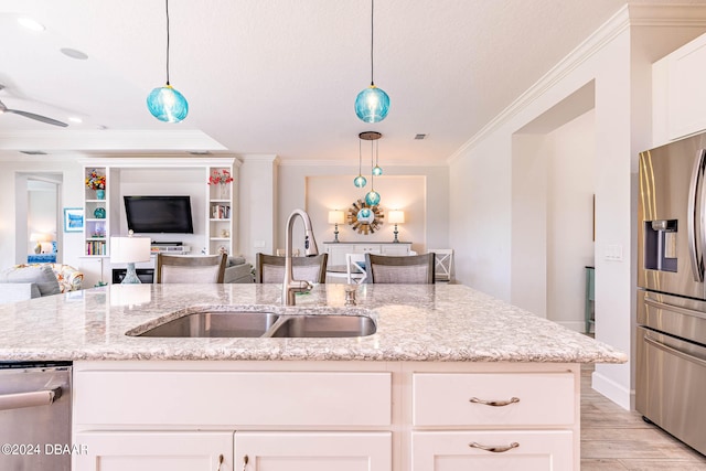 kitchen with hanging light fixtures, stainless steel appliances, light stone counters, and light hardwood / wood-style flooring