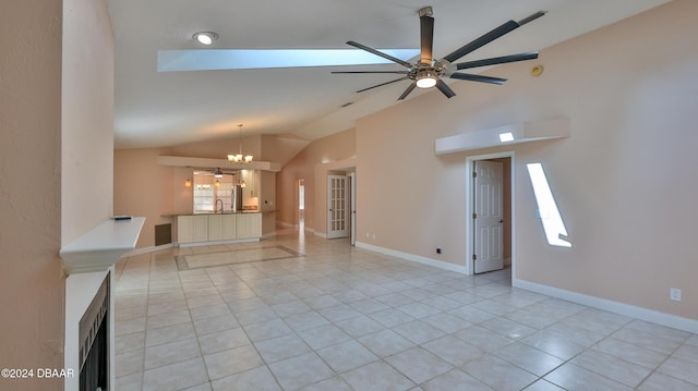 unfurnished living room with ceiling fan with notable chandelier, lofted ceiling, and light tile patterned floors