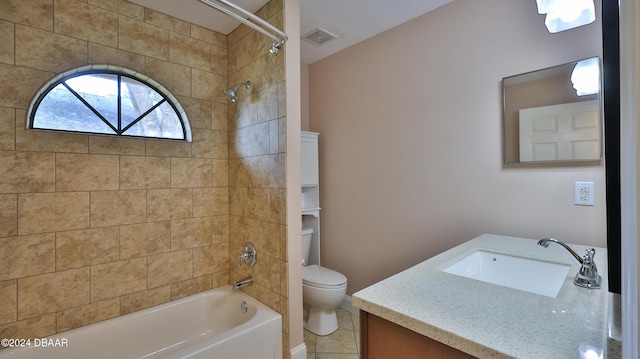 full bathroom featuring tile patterned flooring, vanity, tiled shower / bath combo, and toilet