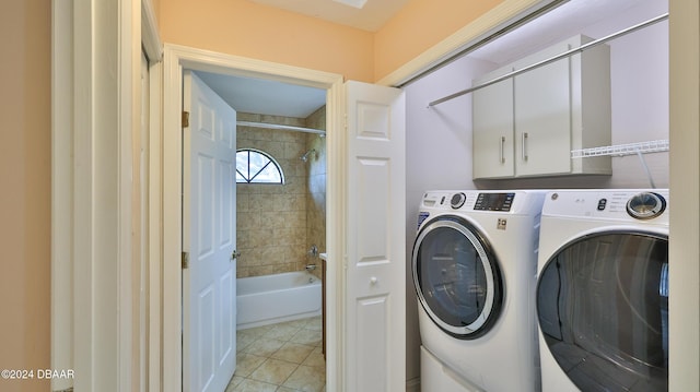 laundry room featuring light tile patterned flooring, cabinets, and separate washer and dryer