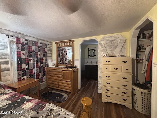 17531 NE 139th Ave, Fort Mccoy, FL 32134 - bedroom featuring a textured ceiling, dark wood-style floors, arched walkways, and ensuite bathroom