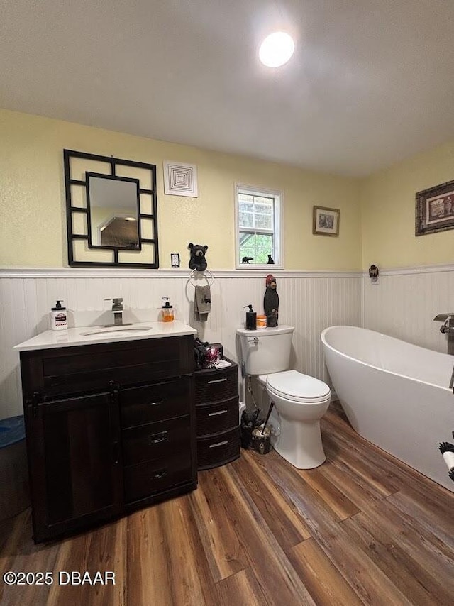 17531 NE 139th Ave, Fort Mccoy, FL 32134 - bathroom with wood finished floors, a freestanding bath, vanity, and wainscoting