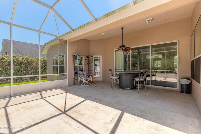 sunroom with outdoor dining area, a ceiling fan, and visible vents