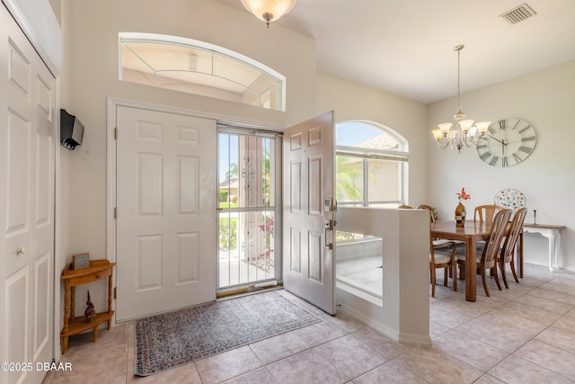 entrance foyer featuring light tile patterned floors, a notable chandelier, and visible vents