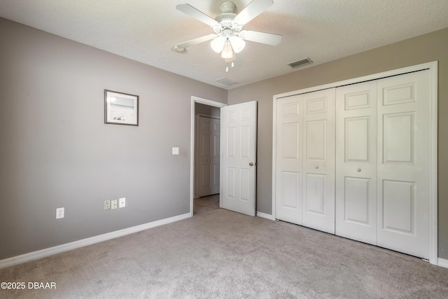 unfurnished bedroom with visible vents, baseboards, a closet, carpet, and a textured ceiling