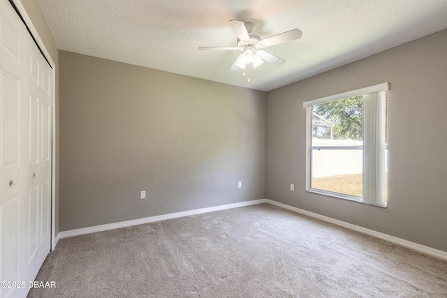 unfurnished bedroom with a closet, baseboards, carpet flooring, and a textured ceiling
