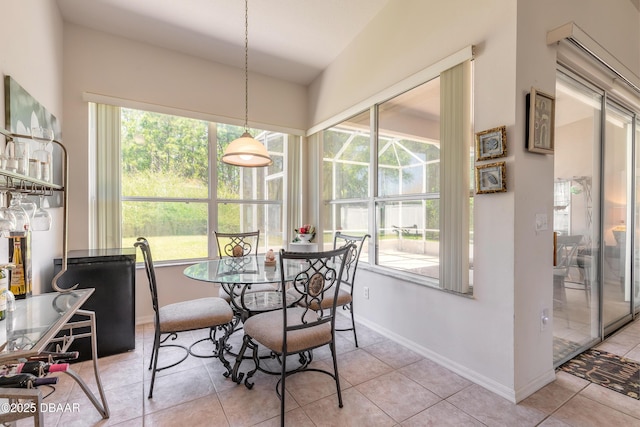 dining space featuring light tile patterned floors, baseboards, and a healthy amount of sunlight