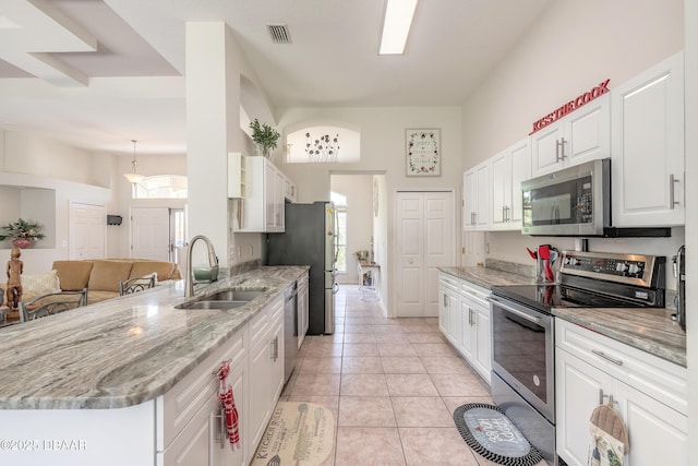 kitchen with white cabinets, light stone countertops, visible vents, appliances with stainless steel finishes, and a sink