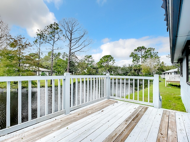 deck with a lawn and a water view