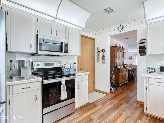 kitchen with white cabinets, stainless steel appliances, and light hardwood / wood-style floors