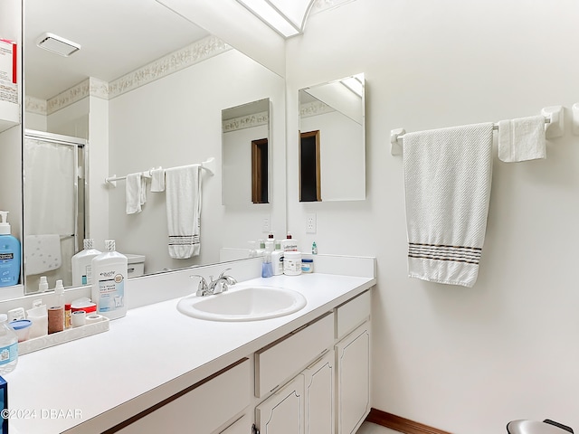 bathroom with a shower with shower curtain, vanity, and toilet