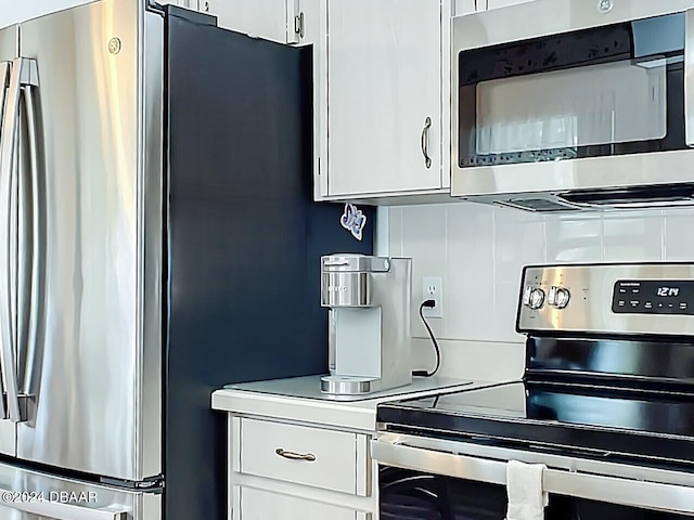 kitchen featuring white cabinets, appliances with stainless steel finishes, and backsplash