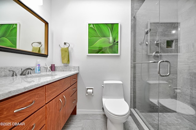 bathroom with a shower with door, vanity, and toilet