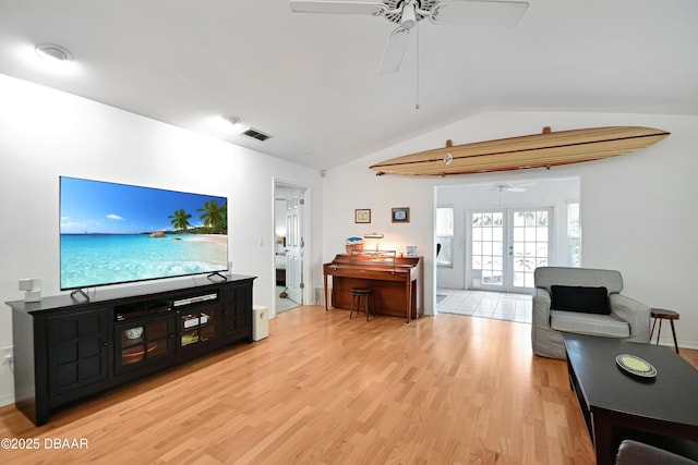 living room with french doors, ceiling fan, lofted ceiling, and light hardwood / wood-style flooring