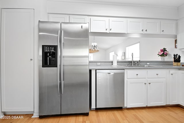 kitchen featuring light wood-type flooring, stainless steel appliances, sink, and white cabinets