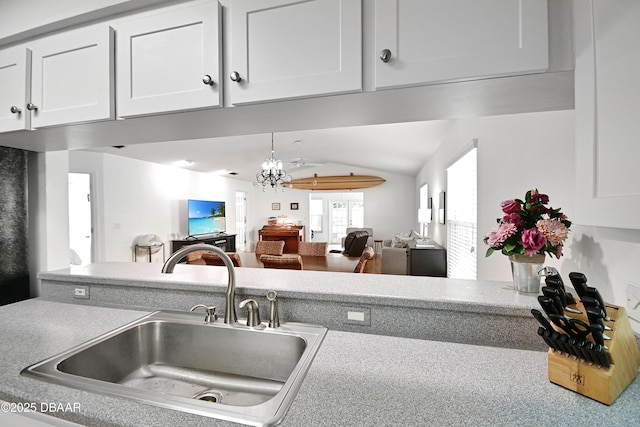 kitchen with white cabinetry, lofted ceiling, and sink