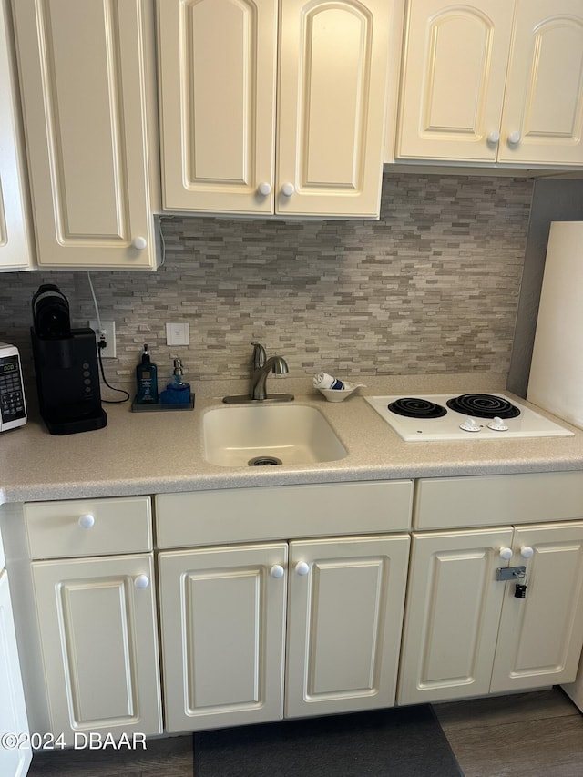 2700 N Atlantic Ave Unit 423, Daytona Beach, FL 32118 - kitchen featuring white cabinets, white electric cooktop, light countertops, and decorative backsplash