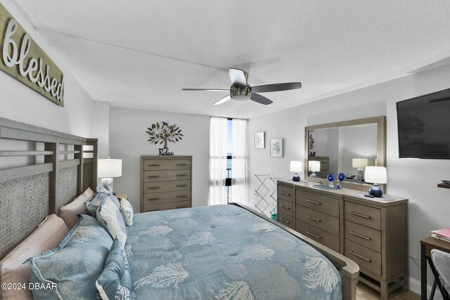 bedroom with ceiling fan and a textured ceiling