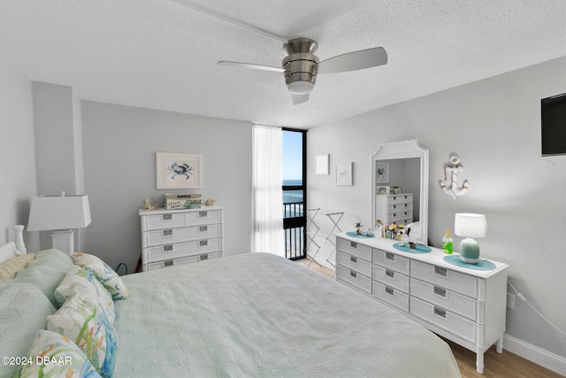 bedroom with ceiling fan, a textured ceiling, and light hardwood / wood-style flooring