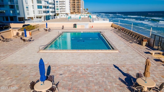 view of pool featuring a water view and a patio area