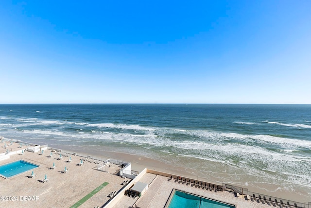 birds eye view of property with a water view and a beach view