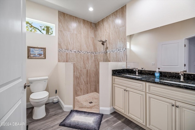 bathroom featuring walk in shower, vanity, hardwood / wood-style flooring, and toilet