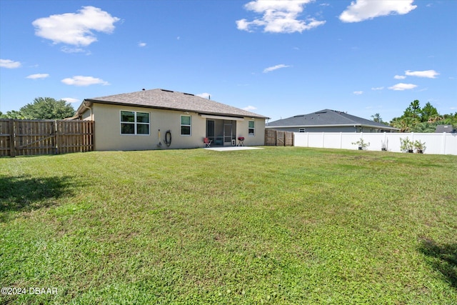 rear view of house with a patio area and a lawn