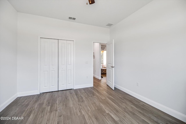 unfurnished bedroom with a closet, hardwood / wood-style flooring, and ceiling fan