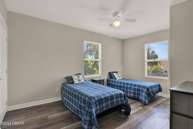 bedroom featuring dark hardwood / wood-style flooring, multiple windows, and ceiling fan