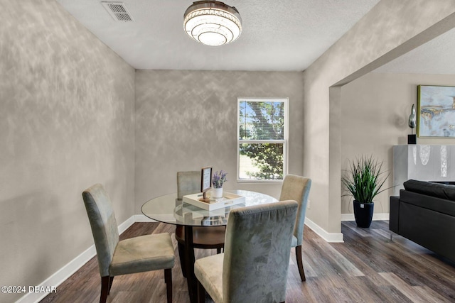 dining area featuring a textured ceiling and dark wood-type flooring