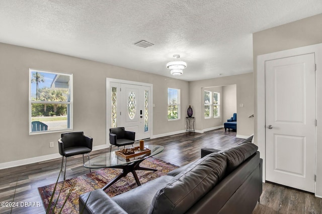 living room featuring dark wood-type flooring and a textured ceiling