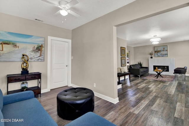 living room featuring ceiling fan and dark hardwood / wood-style flooring