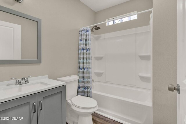 full bathroom with hardwood / wood-style floors, vanity, toilet, and shower / bathtub combination with curtain