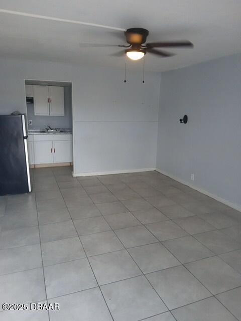 tiled spare room with ceiling fan and sink