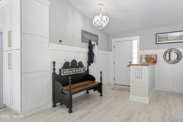 entrance foyer with an inviting chandelier and light hardwood / wood-style flooring