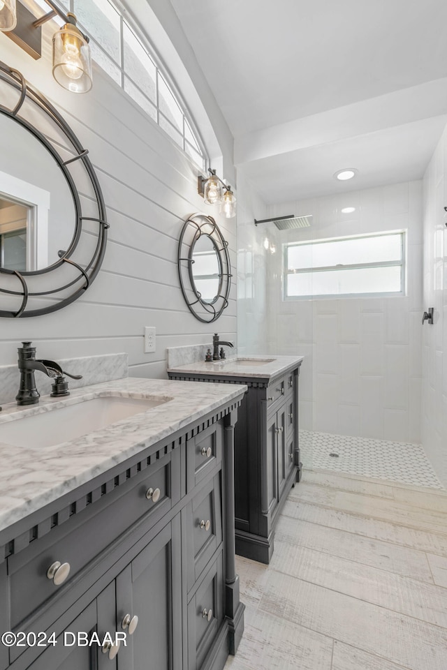 bathroom with a tile shower and vanity